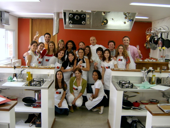 Grupo de alunos da Accademia Gastronomica posando para foto na cozinha da escola ao final de uma aula.